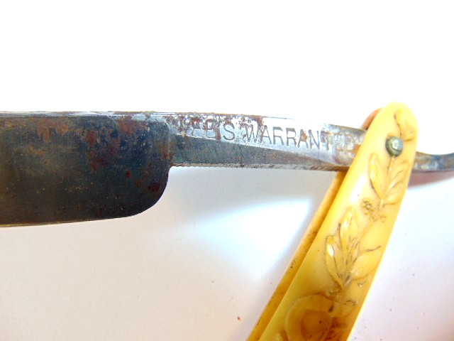 old straight razor with ornately decorated handle labeled ABS Warranted