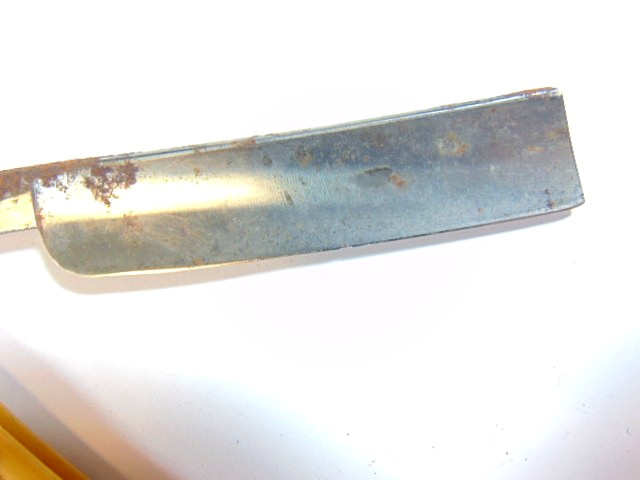 old straight razor with ornately decorated handle labeled ABS Warranted
