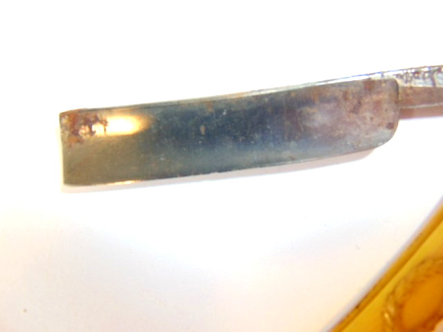 old straight razor with ornately decorated handle labeled ABS Warranted