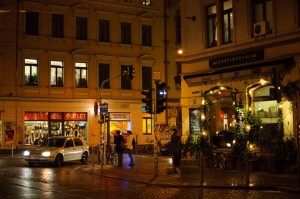Man sieht das Assieck bei Nacht in der Dresdner Neustadt. Menschen stehen an der Ecke.