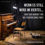 Hintergrund: Ein Klavier mit leerem Stuhl auf einer Bühne. Text: Wenn es still wird im Viertel... Gebt das Budget für die Stadtbezirke frei! Neustadtpiraten.de. Foto-Credit: Elisa Robock.